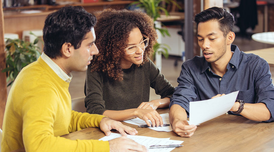 a couple reviewing paperwork with a bank staff member