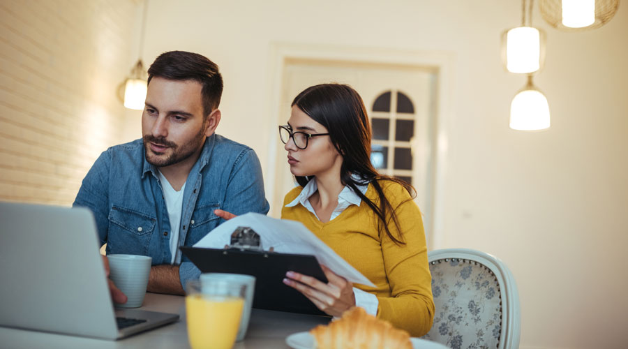 A young couple going through their financial records in the comfort of their home.